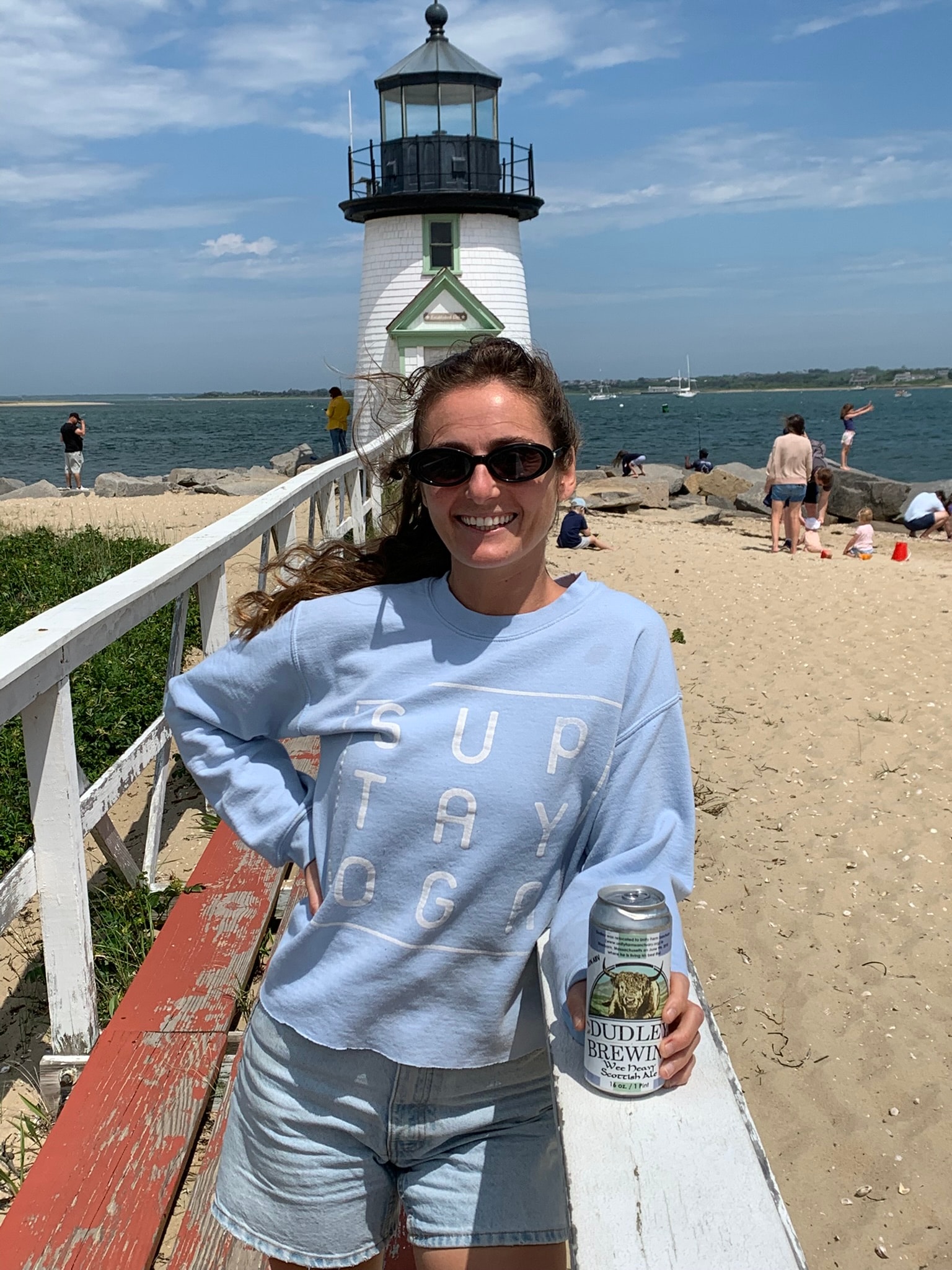 Dudley Brewing fan at Cape Cod lighthouse with a cold craft beer from Wilton NH